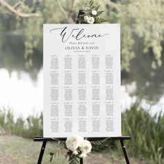 a sign that is sitting on top of a stand with flowers in front of it