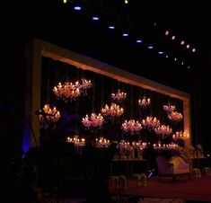 a stage set up with chandeliers and chairs