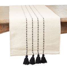 a table runner with black tassels on it