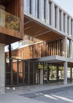 an empty parking lot in front of a building with wooden slats on the sides