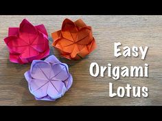 three origami lotus flowers sitting on top of a wooden table