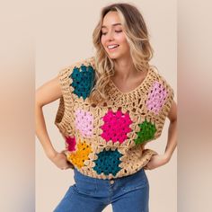 a woman wearing a crocheted sweater with flowers on it