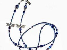 two necklaces with blue beads and silver charms on white background, close up photo