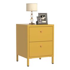 a yellow nightstand with two drawers and a lamp