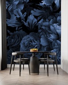 a dining room table with three chairs in front of a blue floral wallpaper mural