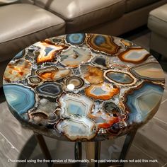 a table that has some kind of colorful design on it, sitting in front of a couch