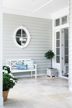 a white bench sitting next to a potted plant