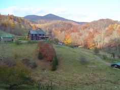 a farm in the fall with mountains in the backgroung and autumn foliage