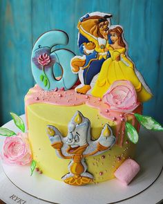 a cake decorated with the characters of beauty and the beast