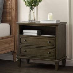 a nightstand with flowers in a vase on top of it next to a night stand