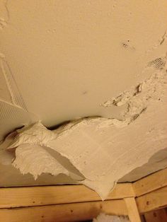 the corner of a room that has been torn off with white paint and some wood