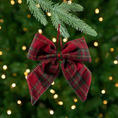 a christmas ornament hanging from a tree with lights in the background