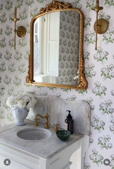 a bathroom sink with a mirror above it next to a wall mounted faucet