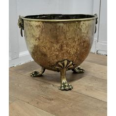 a large metal bowl sitting on top of a wooden floor