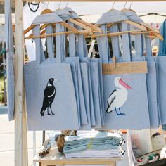 blue linens with birds and seagulls are on display at an outdoor market