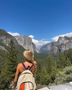 a woman with a backpack looking at the mountains in yose, yose national park