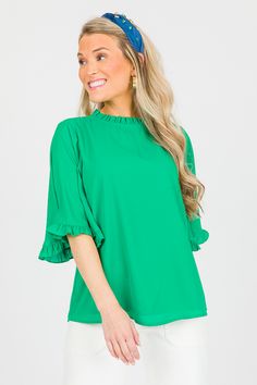 Simple with a heavy dose of sweet. This blouse features a ruffle trimmed neckline and bell sleeves for an extra feminine push. Pair it with trousers for the work week, tucked into a skirt for church, or style it more casually with denim! Fall Workwear Blouse With Ruffle Hem, Green Pleated Sleeves Blouse For Spring, Spring Blouse With Ruffle Hem For Work, Spring Workwear Blouse With Ruffle Hem, Spring Blouse With Pleated Sleeves And Ruffled Collar, Stretch Blouse With Ruffles For Spring, Stretch Blouse With Ruffle Sleeves For Work, Chic Tops With Ruffle Hem And Bell Sleeves, Stretch Ruffle Sleeve Blouse For Work