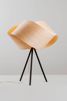 a wooden table lamp sitting on top of a tripod