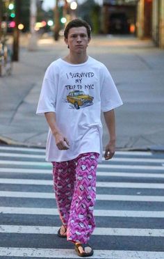 a man walking across a cross walk wearing pajamas