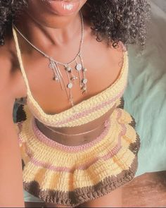 a close up of a person wearing a dress and necklace with an afro hairstyle