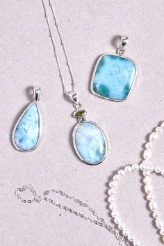 Larimar is the ultimate summer jewellery! The Larimar stone paired with Peridot make that lovely pendant that will be the perfect piece to wear all summer. The stones are set on a 925 sterling silver double bezel. Dimensions: Total height: 42mm Total width: 20mm Top stone height: 3mm Top stone width: 6mm Bottom stone height: 23mm Bottom stone width: 16mm Bezel + stone thickness: 4mm Bail size: 4mm - Please note - * More photos or videos available on request. * Go to 'About us' section to find links to our social and website * Only the pendant and without the chain is included in the price * Gemstones are natural material, they can slightly differ in color, size, shape and may show some inclusions or cracks inside the stone itself. We do take great care in picking the best quality stones fo Fine Jewelry White Aquamarine, White Larimar Gemstone Jewelry, White Aquamarine Fine Jewelry, Fine White Aquamarine Jewelry, Aquamarine Pendant With Natural Stones, White Larimar Round Jewelry, Aquamarine Pendant Jewelry With Natural Stones, Aquamarine Gemstone Jewelry For Jewelry Making, Larimar Cabochon Jewelry Gift