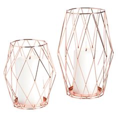 two pink vases sitting next to each other on a white surface with one candle in the middle