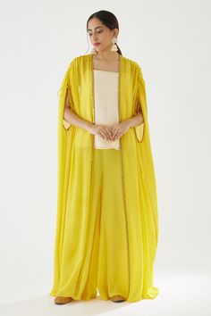 Yellow cape with coin embroidered border. Paired with cream camisole top and sharara.
Components:3
Pattern:Embroidery
Type of Work:Coin
Neckline:Cape: Open, Top: Square
Sleeve Type:Cape: Flared sleeves, Top: Sleeveless
Fabric:100% Viscose Georgette
Color:Yellow,Cream
Other Details:
Drawstring detailing on sleeve hem
Occasion:Sangeet - Aza Fashions Georgette Sharara, Sharara Designs, Embroidered Cape, Flared Sleeves Top, Embroidered Border, Sharara Set, Pattern Embroidery, Yellow Cream, Indian Fashion Designers