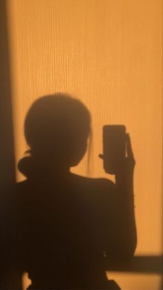 the shadow of a person holding a cell phone