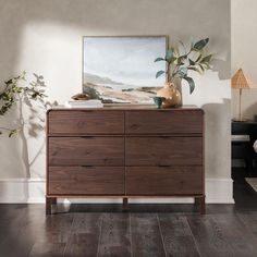 a wooden dresser sitting in a living room next to a painting