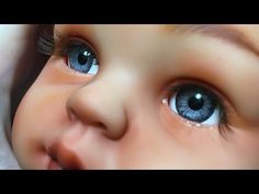 a close up of a baby's face with blue eyes