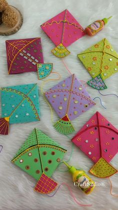 several colorful kites sitting on top of a white blanket