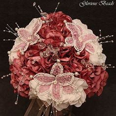 a bridal bouquet with pink and white flowers, pearls and butterfly brooches