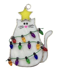 a white cat ornament with christmas lights hanging from it's back and a star on top