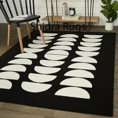 a black rug with white circles on it in front of a wooden table and chair