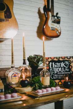 a table topped with candles and cakes next to guitars