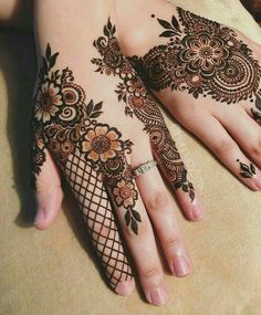 a woman's hand with henna tattoos on it, and her hands are shown