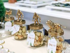 three glass jars filled with nuts sitting on top of a table next to each other