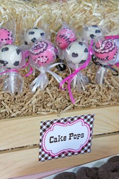 there are chocolate covered cake pops in the wooden box with pink and black designs on them