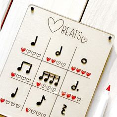 a music note board with musical notes and hearts on it, next to a pen