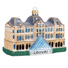 a christmas ornament with a large building on it's side and the words louvre in front