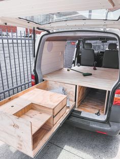 the back end of a van with its cargo door open and drawers in place on the side