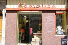 a store front with boxes stacked up in the window and an orange awning above it