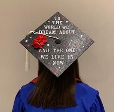 a woman wearing a graduation cap that says to the world we dream about and the one we live in now