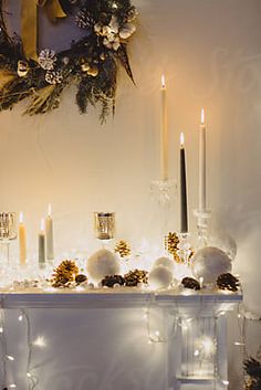 a mantle decorated with candles and christmas decorations