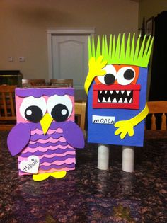 two paper cut outs with an owl and monster on them sitting on a counter top