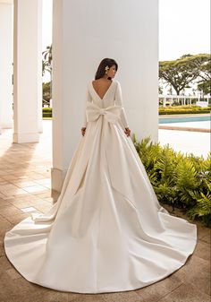 a woman in a white wedding dress standing outside