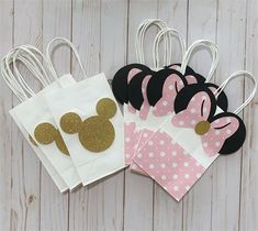 minnie mouse party bags with pink and white polka dot paper, gold mickey ears on them