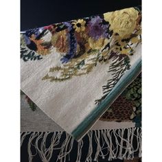 two rugs with flowers on them sitting next to each other in front of a black background