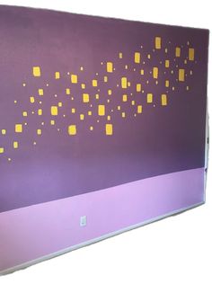 a purple wall with yellow squares on it