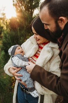 a man and woman holding a baby in their arms